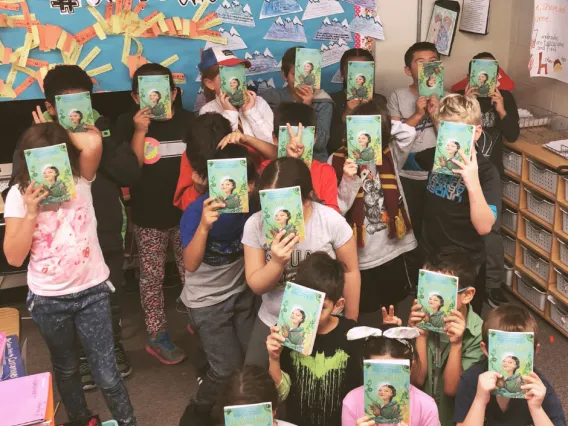 Students holding up novels